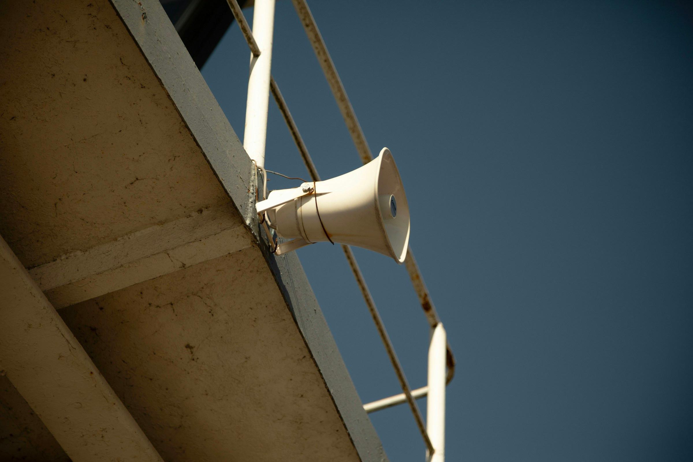 Commercial PA horn speaker mounted on an industrial building structure
