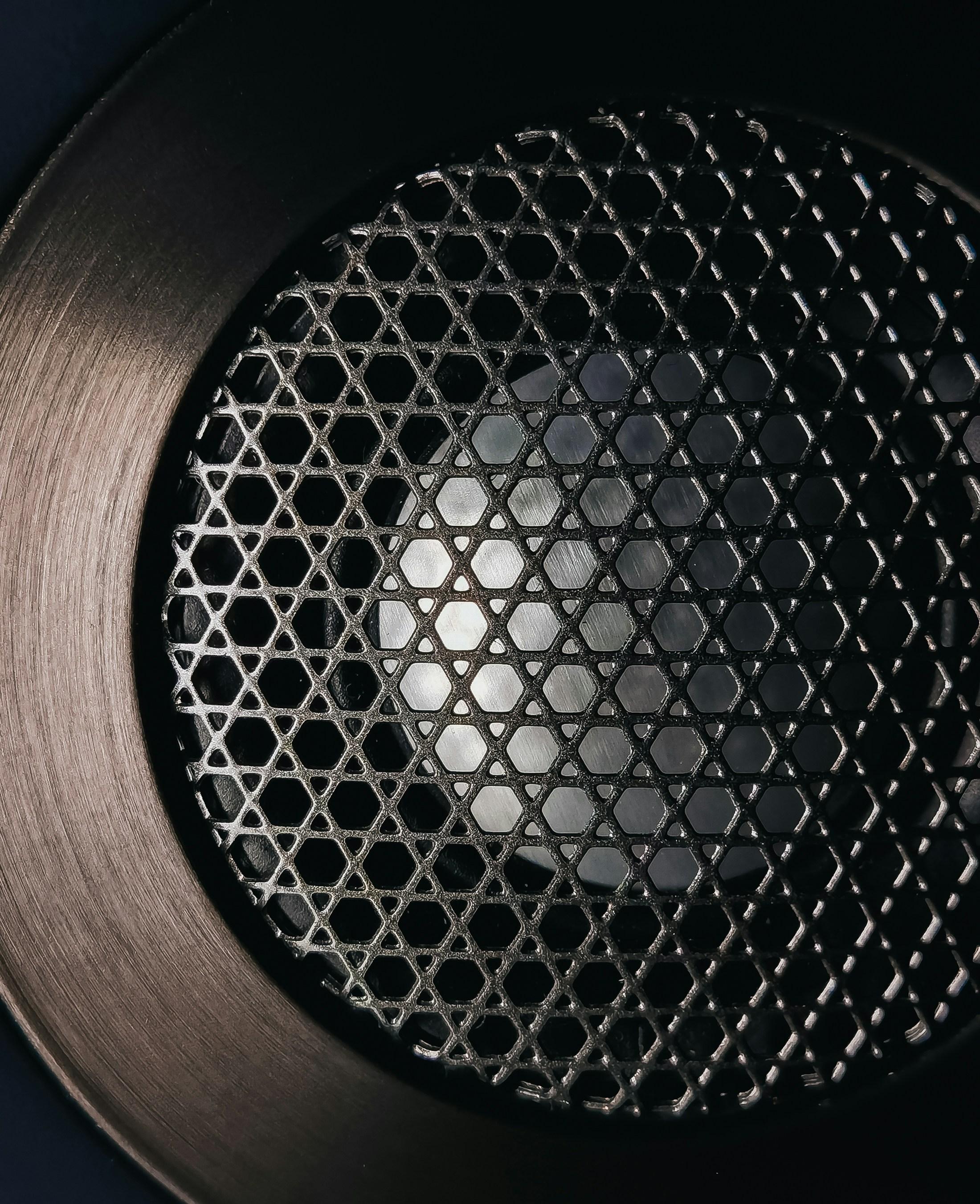 Close-up of a premium paging speaker grille with dramatic lighting