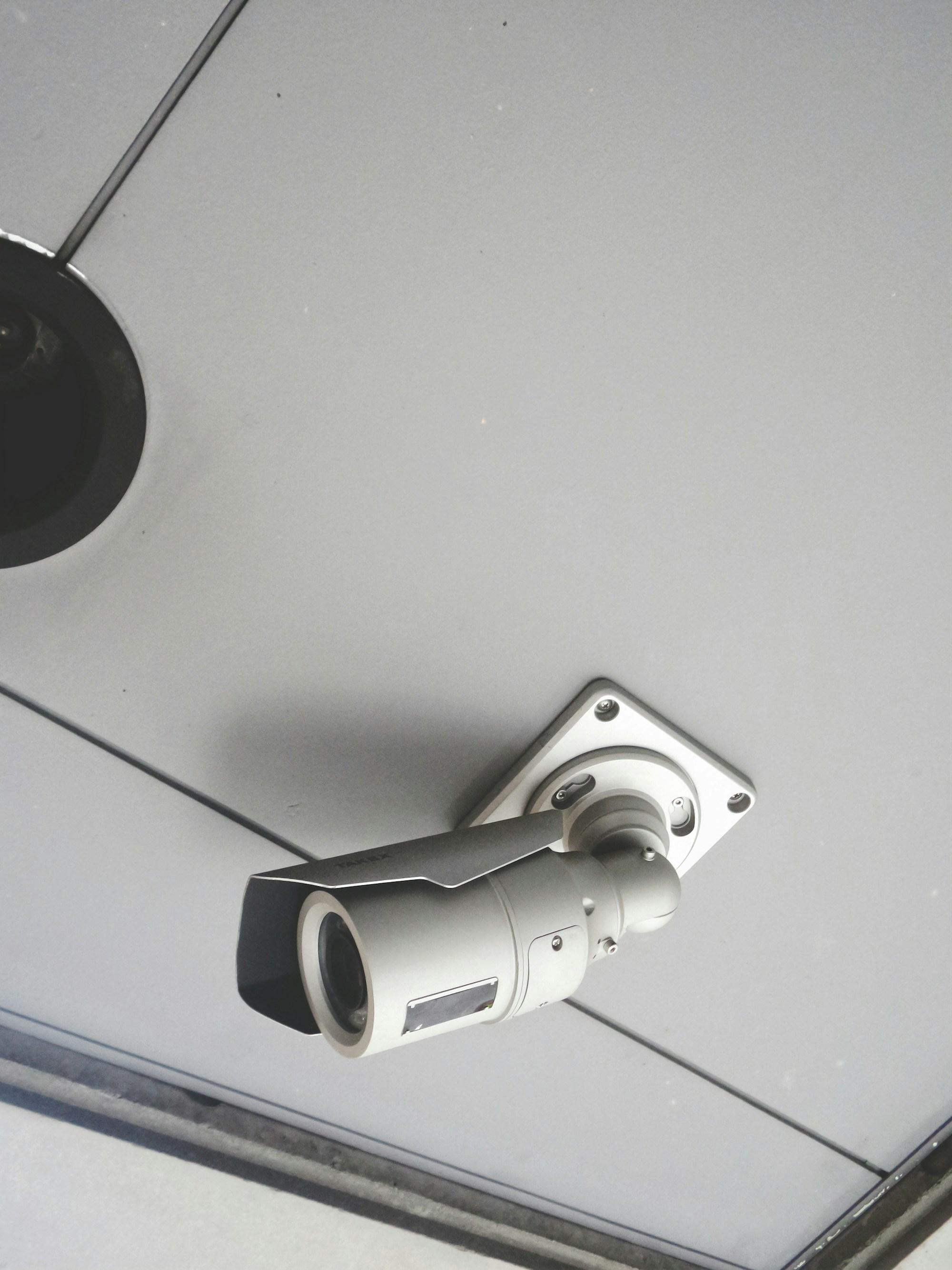 Security camera mounted to the ceiling of a commercial building